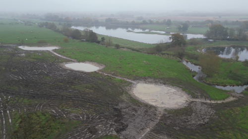 bird's eye view of the completed scrapes - a number of large shallow pools of water connected by thin streams called swales